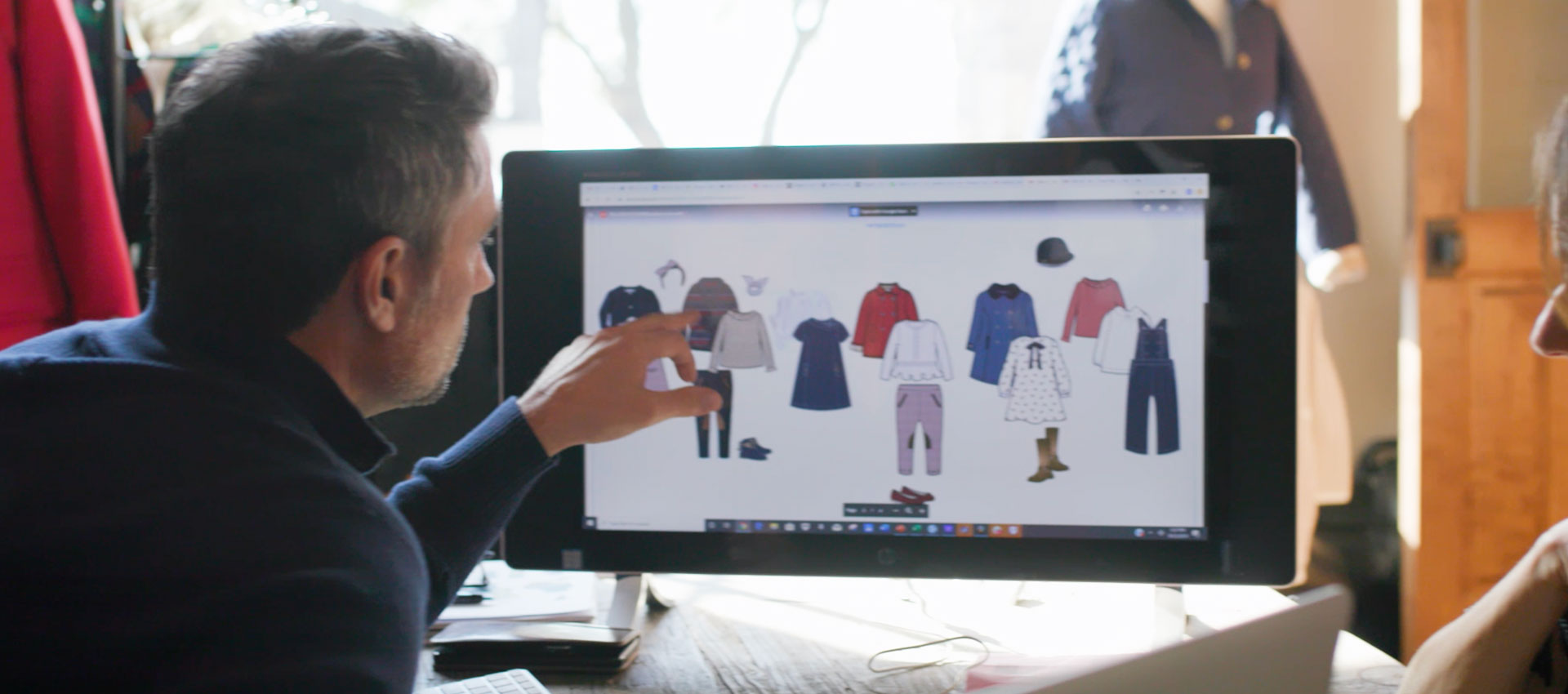 Man looking at fashion clothing designs on a computer