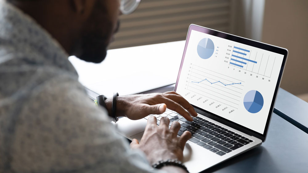 Man looking at graphs and charts on a computer