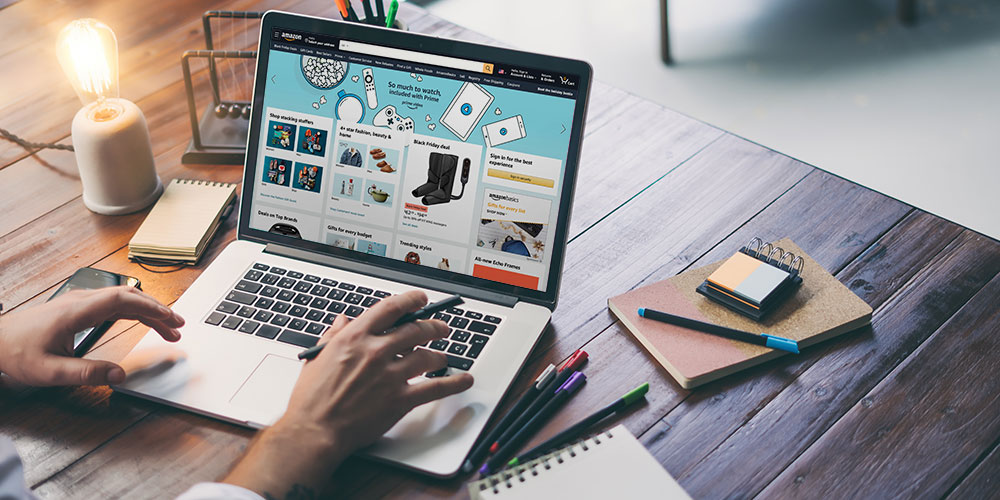 hands on a laptop computer with the Amazon.com homepage open