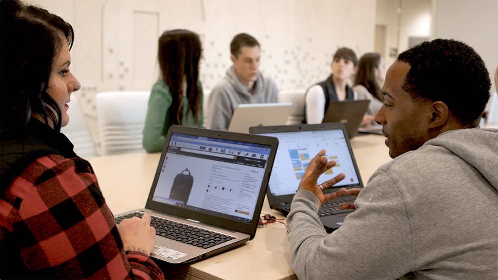 two people on laptops talking to eachother